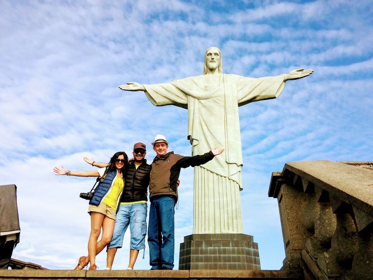Guests celebrating beneath Christ the Redeemer on a bright morning