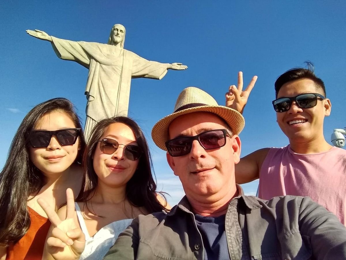 A smiling group selfie in front of Christ the Redeemer