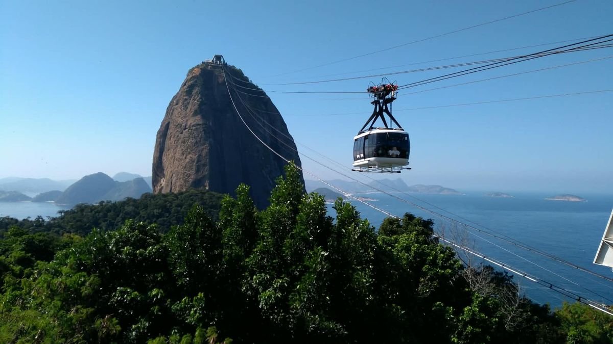 The cable car gliding toward Sugarloaf Mountain above the forest and bay